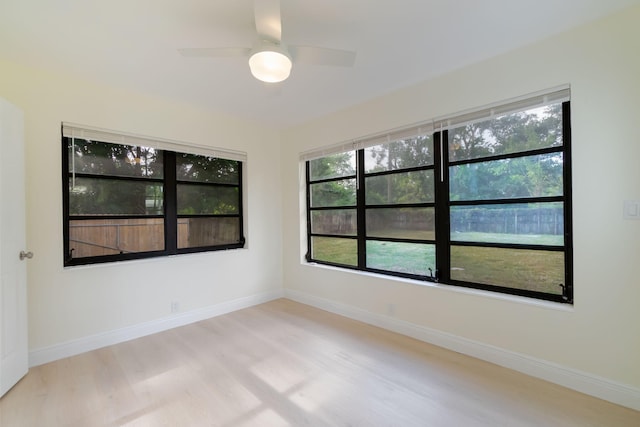 unfurnished room featuring plenty of natural light, ceiling fan, and light wood-type flooring