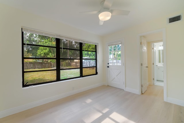 empty room with ceiling fan and light hardwood / wood-style floors