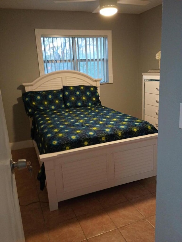 tiled bedroom featuring ceiling fan