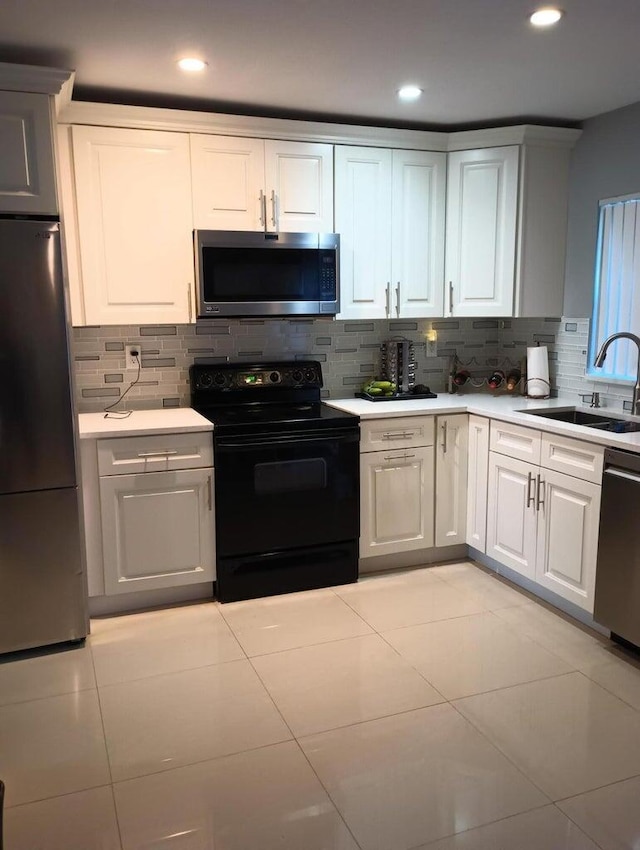 kitchen with stainless steel appliances, white cabinetry, and sink