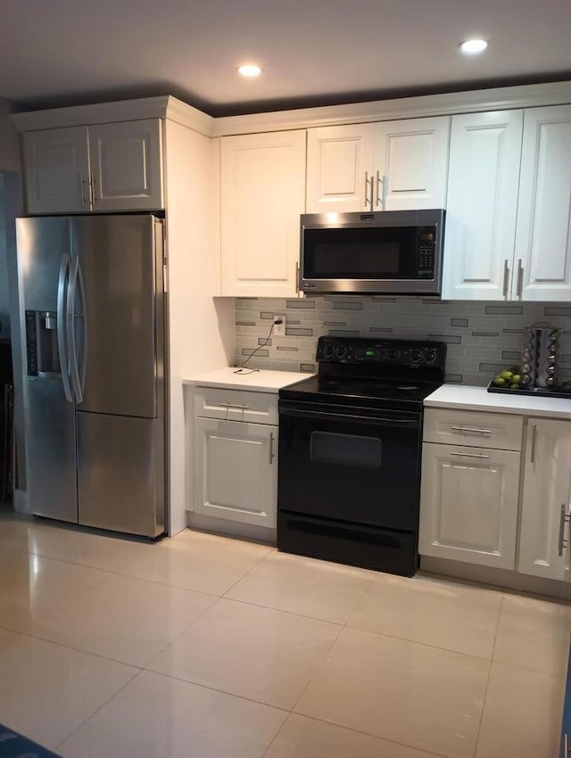 kitchen with decorative backsplash, white cabinetry, and appliances with stainless steel finishes