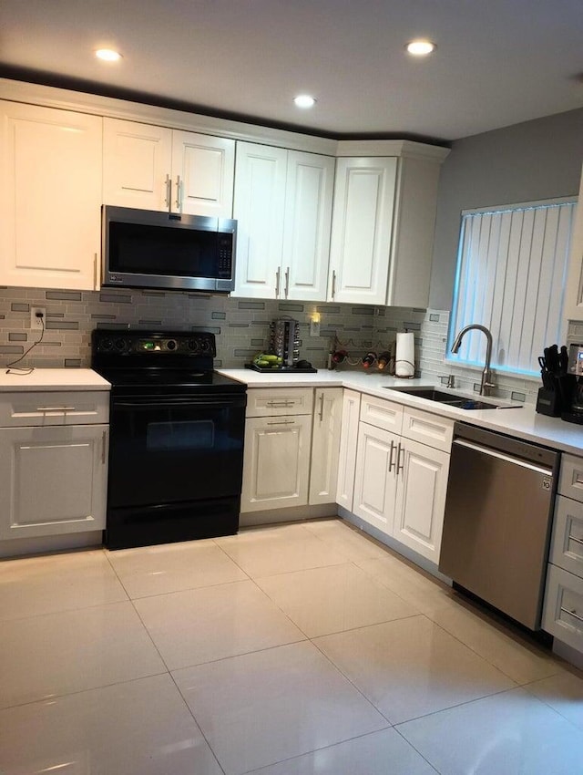 kitchen featuring backsplash, white cabinetry, sink, and appliances with stainless steel finishes