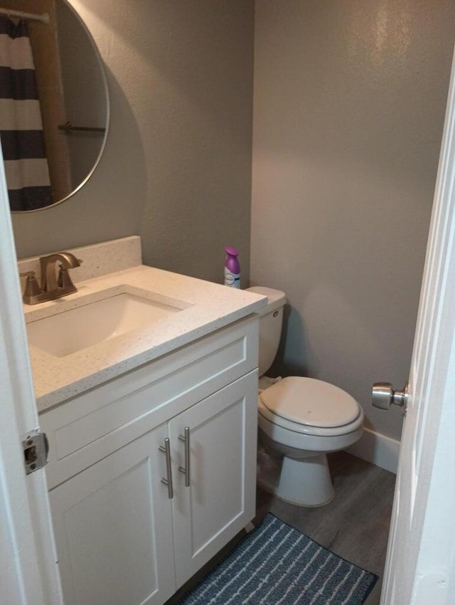 bathroom featuring vanity, wood-type flooring, and toilet