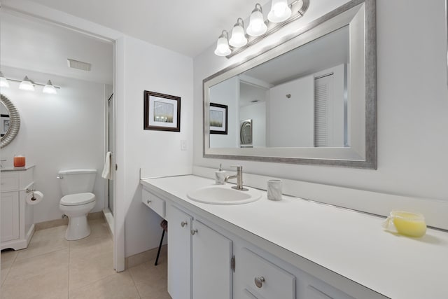 bathroom with tile patterned flooring, vanity, a shower with door, and toilet