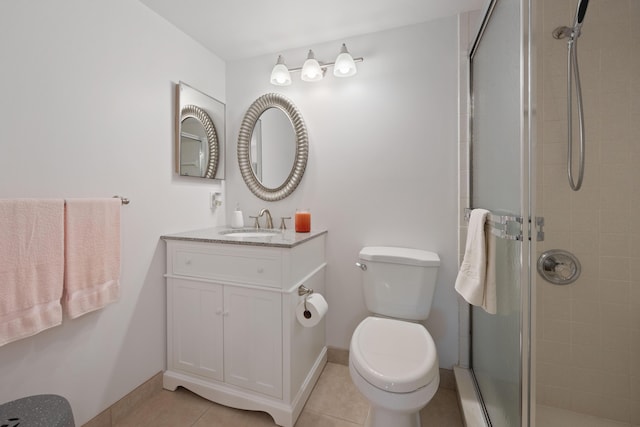 bathroom featuring tile patterned flooring, vanity, a shower with door, and toilet