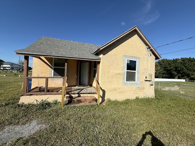 rear view of house featuring a yard