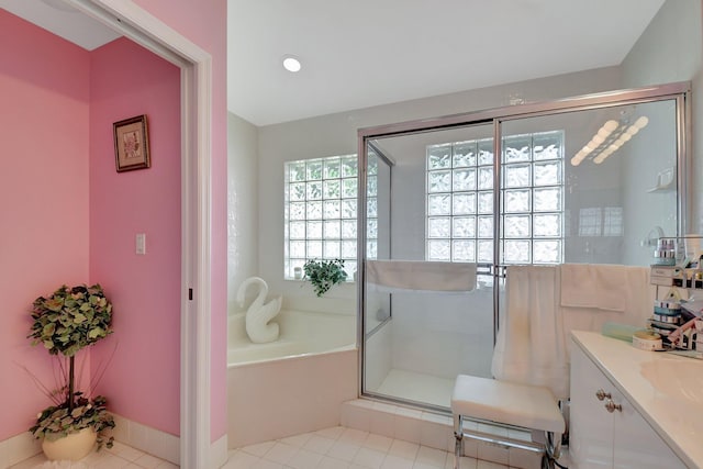 bathroom with plus walk in shower, vanity, and tile patterned flooring