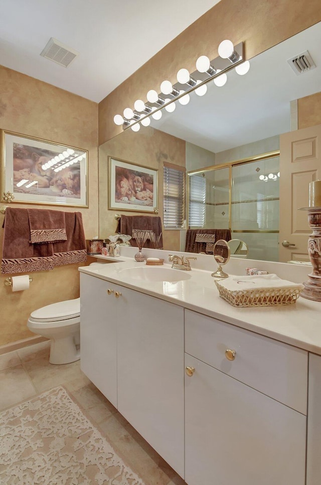 bathroom featuring toilet, a shower with door, vanity, and tile patterned flooring