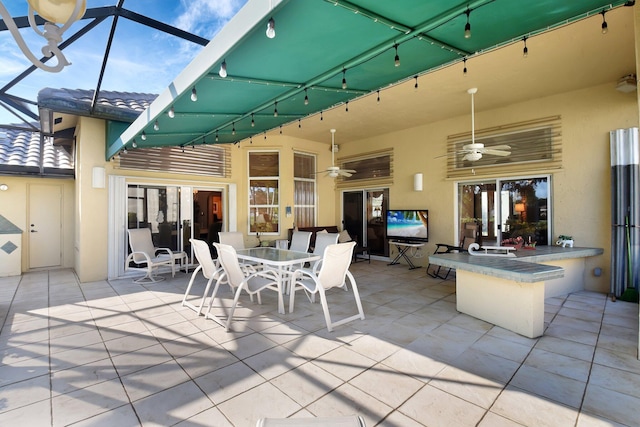 view of patio with glass enclosure and ceiling fan