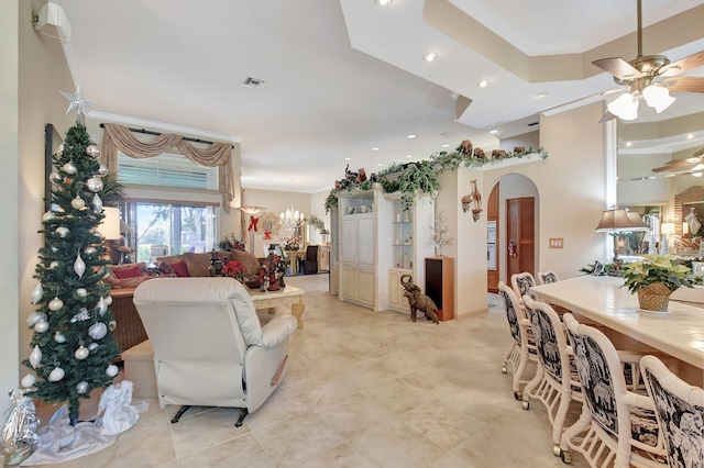 living room featuring ceiling fan with notable chandelier