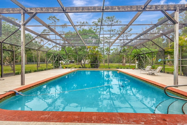 view of swimming pool with glass enclosure and a patio area