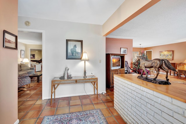 hallway featuring tile patterned floors and a textured ceiling