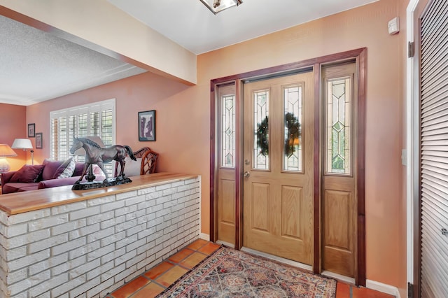 foyer with light tile patterned floors and a textured ceiling