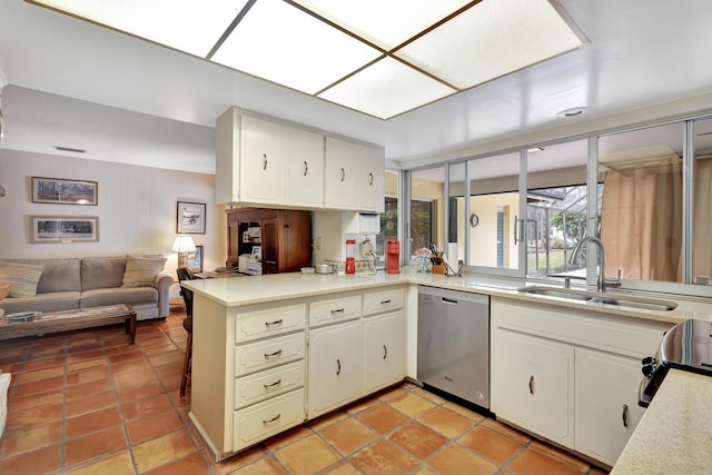 kitchen featuring white cabinetry, dishwasher, sink, kitchen peninsula, and wooden walls