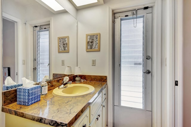 bathroom with a skylight, a wealth of natural light, and vanity