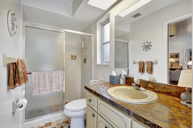 bathroom featuring vanity, a shower with shower door, and toilet