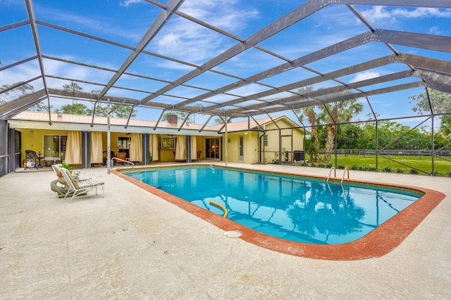 view of pool featuring glass enclosure and a patio