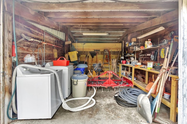 basement featuring a workshop area, wooden walls, and washing machine and clothes dryer