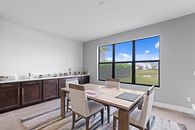 dining room with a water view and light tile patterned floors