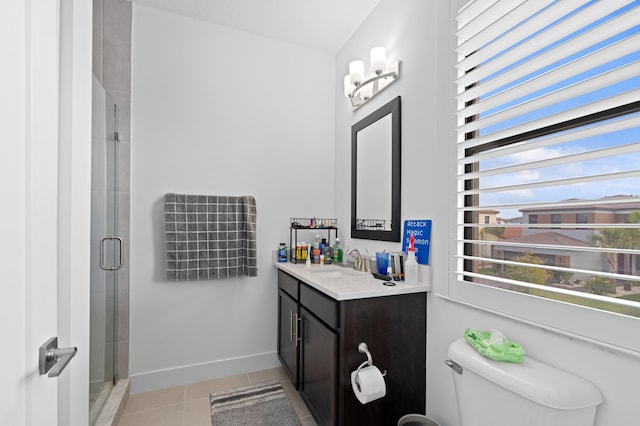 bathroom featuring tile patterned floors, vanity, an enclosed shower, and toilet