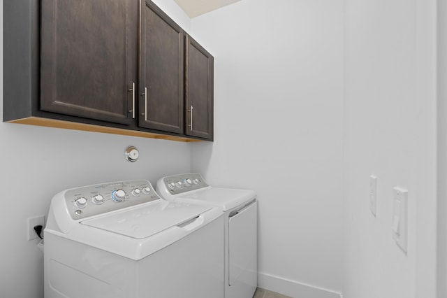 laundry room with washing machine and dryer and cabinets