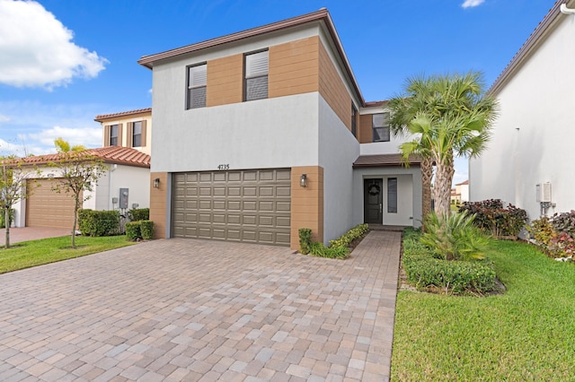 view of front of property with a garage and a front lawn