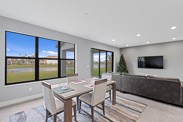 tiled dining area featuring a water view