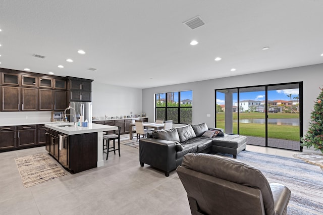 living room featuring a water view and sink