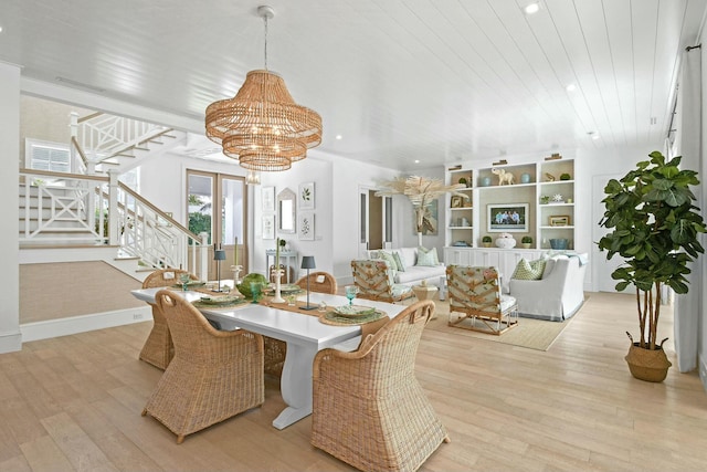 dining space with a notable chandelier, light hardwood / wood-style floors, and wood ceiling