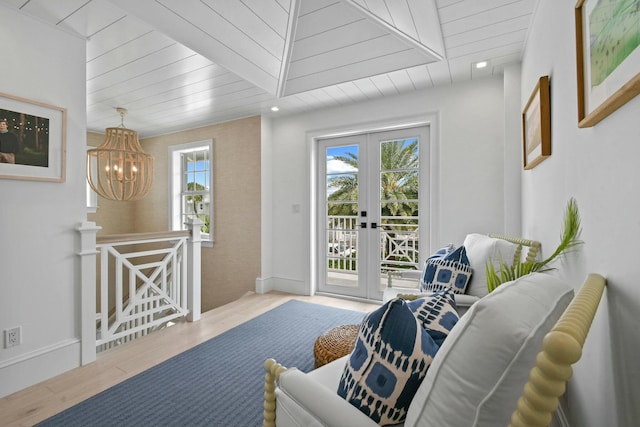 sitting room with an inviting chandelier, light hardwood / wood-style floors, and french doors