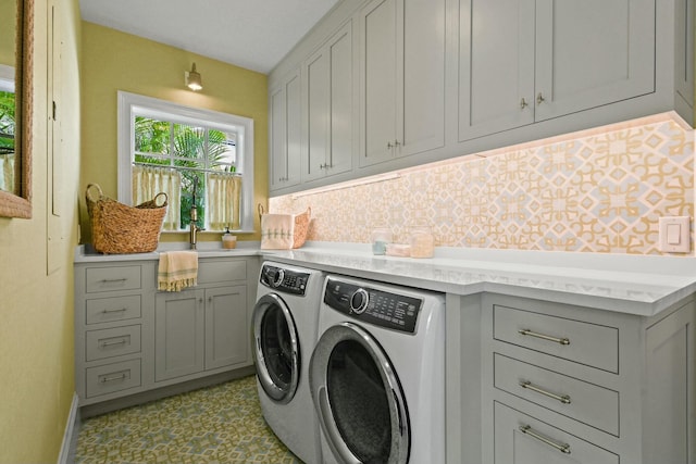 laundry area featuring cabinets, sink, and washing machine and clothes dryer