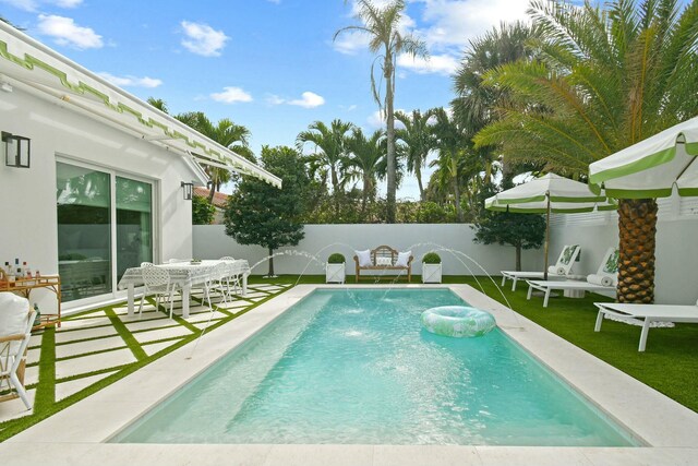 view of swimming pool featuring pool water feature and a patio