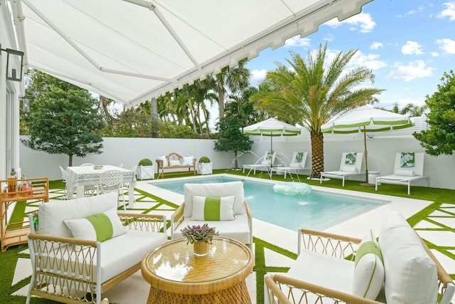 view of pool with outdoor lounge area and pool water feature