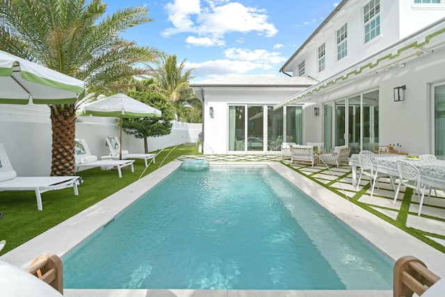 view of pool featuring a lawn and a patio area