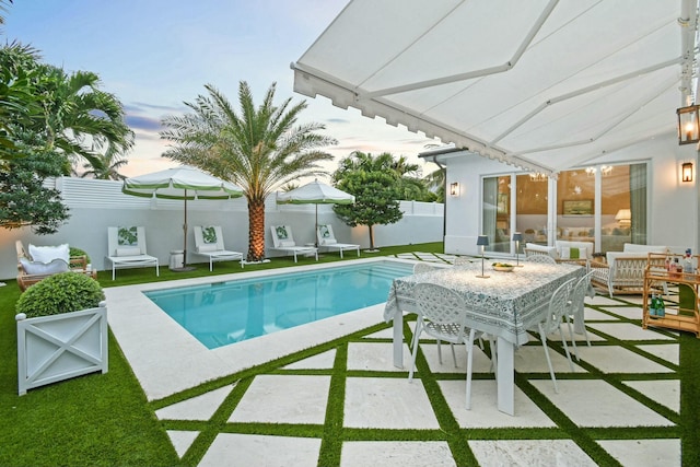 pool at dusk featuring a patio