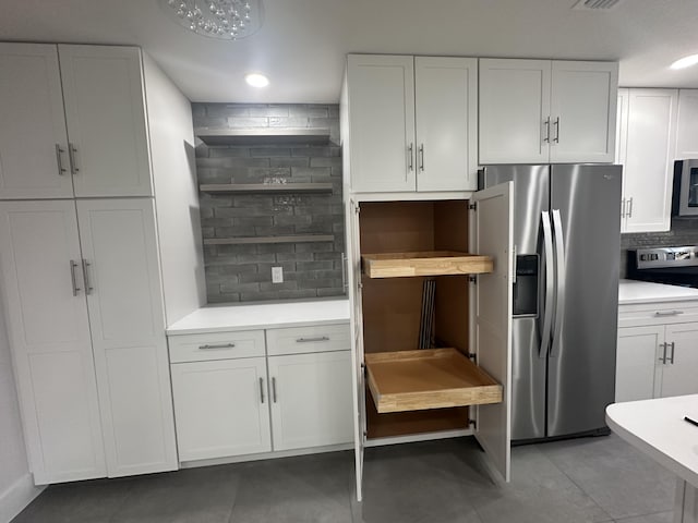 kitchen featuring tasteful backsplash, white cabinetry, and appliances with stainless steel finishes