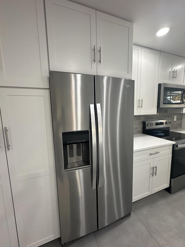 kitchen featuring white cabinets, decorative backsplash, and stainless steel appliances