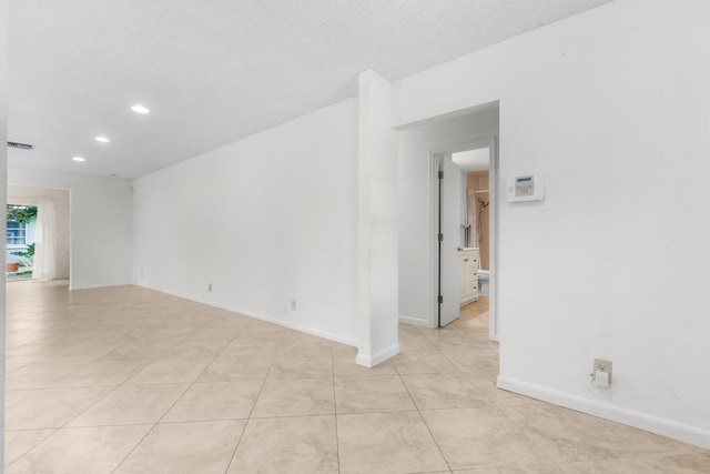 spare room with light tile patterned floors and a textured ceiling