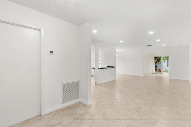 spare room with light tile patterned floors and a textured ceiling