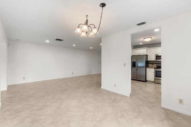 unfurnished room featuring light tile patterned floors, a chandelier, and a textured ceiling