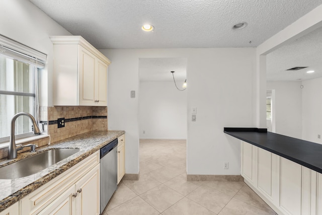 kitchen with sink, stainless steel dishwasher, cream cabinets, a textured ceiling, and decorative backsplash