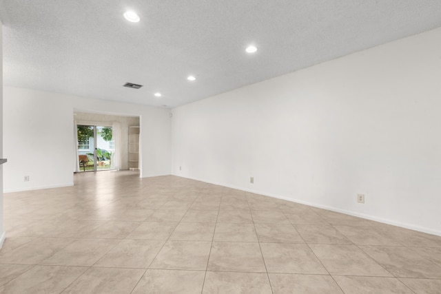 unfurnished room with light tile patterned floors and a textured ceiling