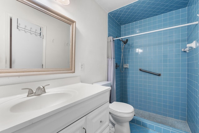 bathroom with a tile shower, vanity, toilet, and tile patterned floors