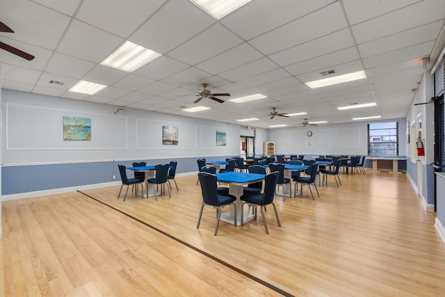 dining space featuring hardwood / wood-style floors, a paneled ceiling, and ceiling fan