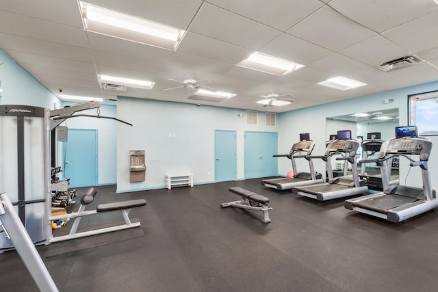 workout area featuring ceiling fan and a drop ceiling