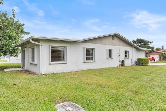 exterior space with central AC and a front lawn