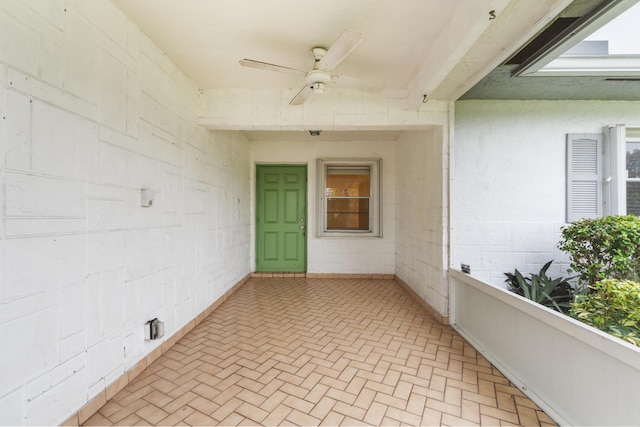 entrance to property with ceiling fan and a balcony