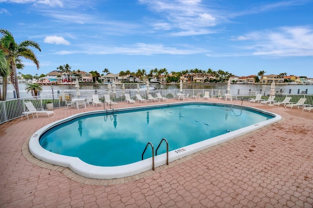 view of pool featuring a patio area and a water view