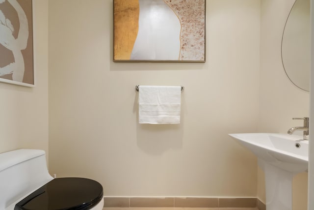 bathroom with tile patterned flooring, toilet, and sink