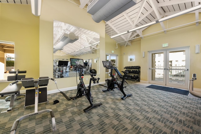 exercise room with carpet flooring, french doors, and high vaulted ceiling